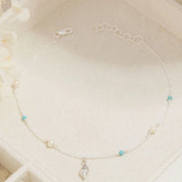 Delicate anklet with small beads on a white background