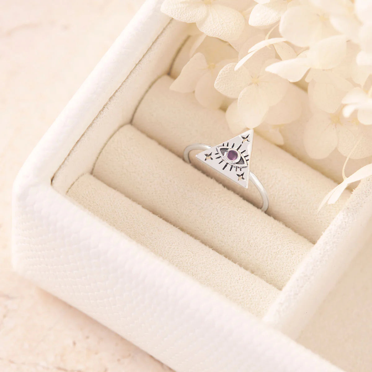 Silver ring with a amethyst gemstone in a beige jewelry box