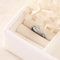 Silver ring with intricate snake design in a jewelry box